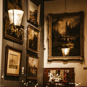 A cozy gallery corner showcasing luxury paintings and sculptures in warm lighting.