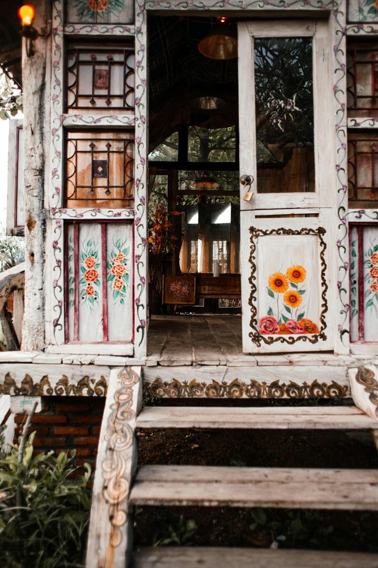 Beautifully painted rustic wooden doorway with floral designs and intricate details.
